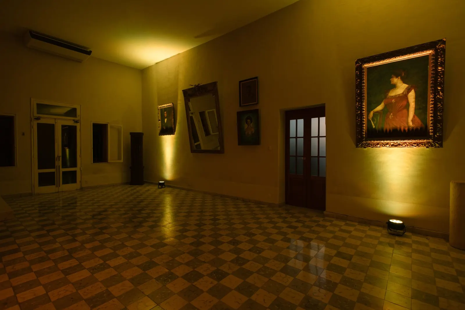 El salón secundario con los cuadros, de noche