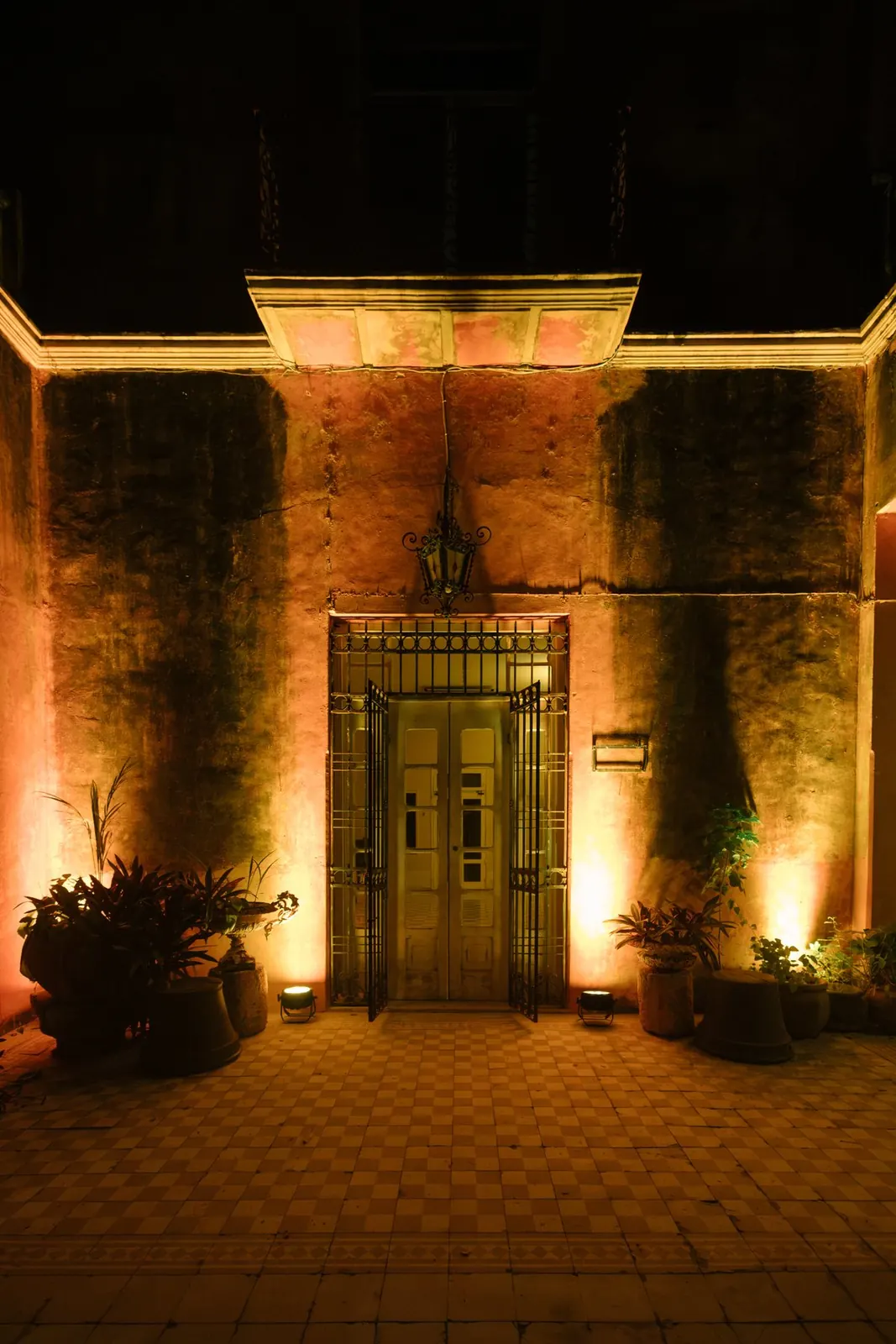 La puerta principal con el farol, de noche