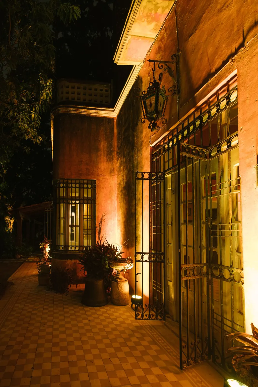 La terraza con la reja y las macetas, de noche